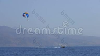 摩托艇将一个特殊的降落伞拖过海面